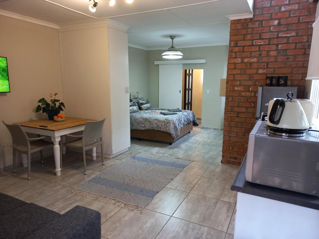 Habitación con cama y mesa con mesa en Lazy Days Apartments - Jeffreys Bay, en Jeffreys Bay