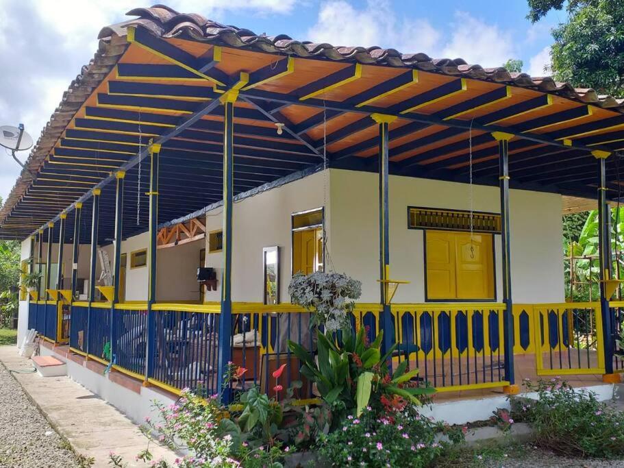 a yellow and blue house with a blue fence at Casa Finca Villa Luz a 800 mts del Parque del Café in Montenegro