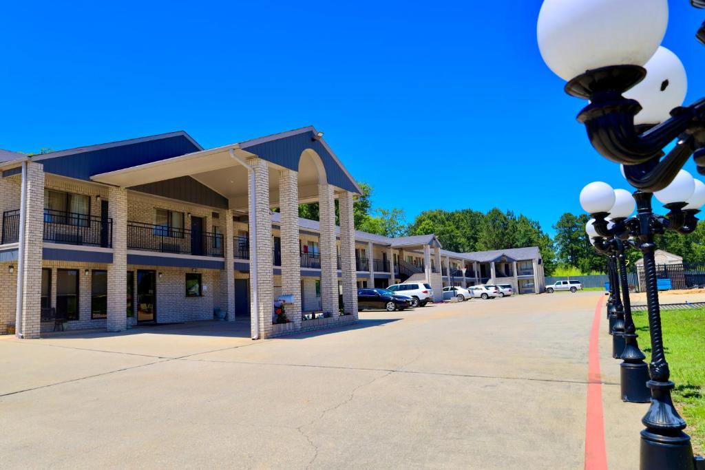 um edifício com uma luz de rua em frente em Regency Inn & Suites em Gladewater