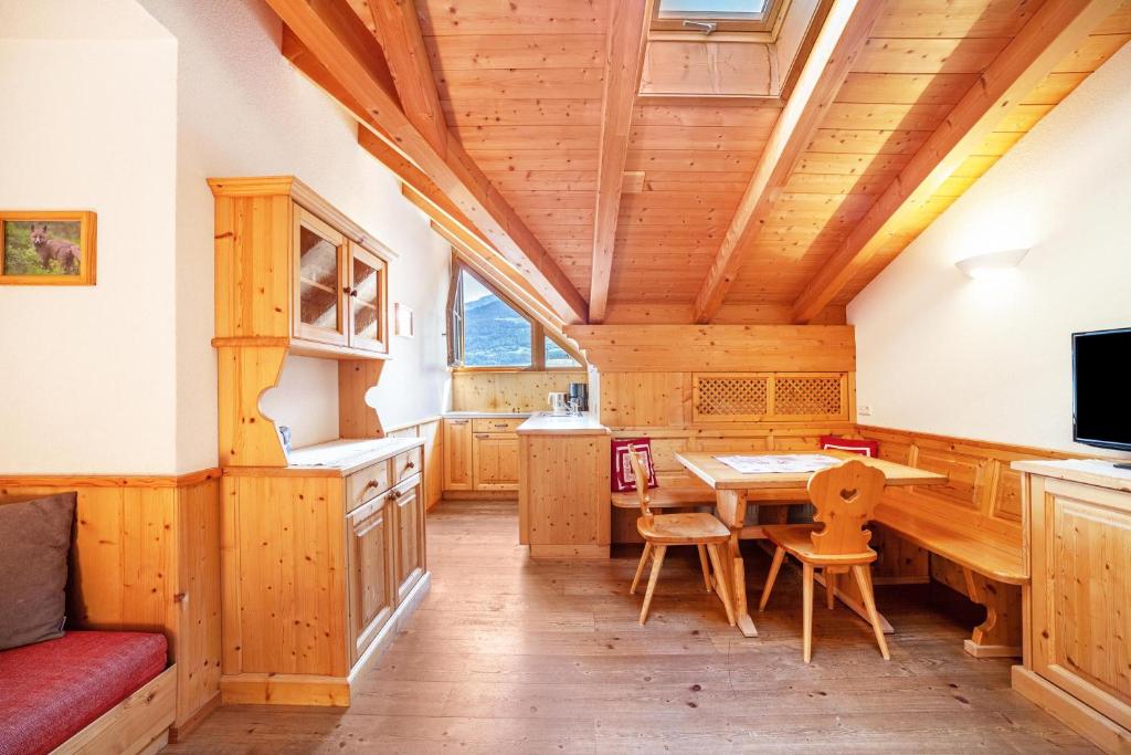 una cucina e una sala da pranzo con soffitto in legno di Hof am Schloss Apartement Zirm a Montechiaro