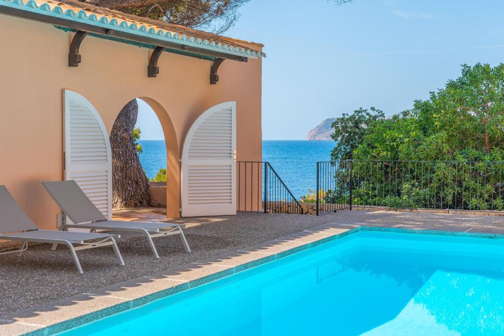 a villa with a swimming pool next to the ocean at Villa Lumb in Capdepera