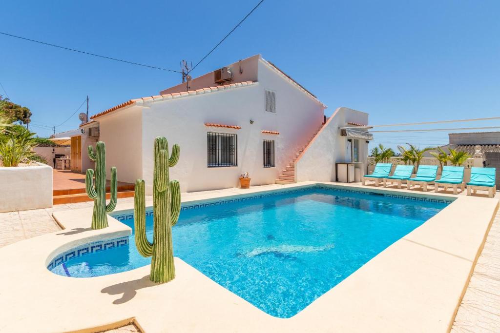 een villa met een zwembad en een cactus bij Villa with private Heated pool in Casas de Torrat
