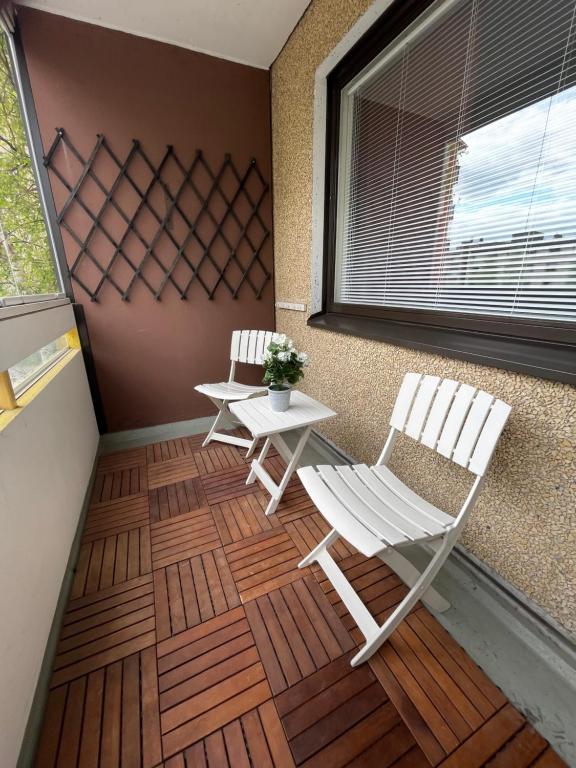 porche con 2 sillas, mesa y ventana en Polar apartment en Rovaniemi