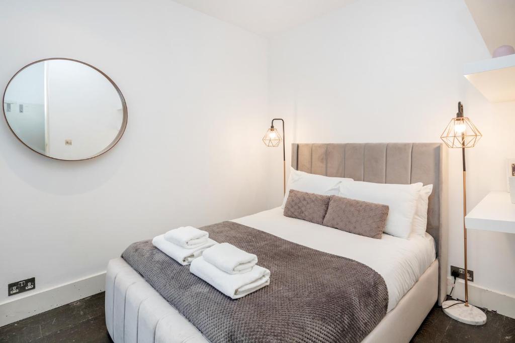 a bedroom with a large bed with towels on it at Beautiful 2 bedroom Covent Garden apartment in London