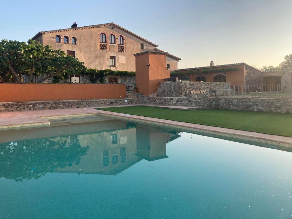 una casa y una piscina frente a un edificio en Mas Teixidor, Masia entre Girona y la Costa Brava, en Caldes de Malavella