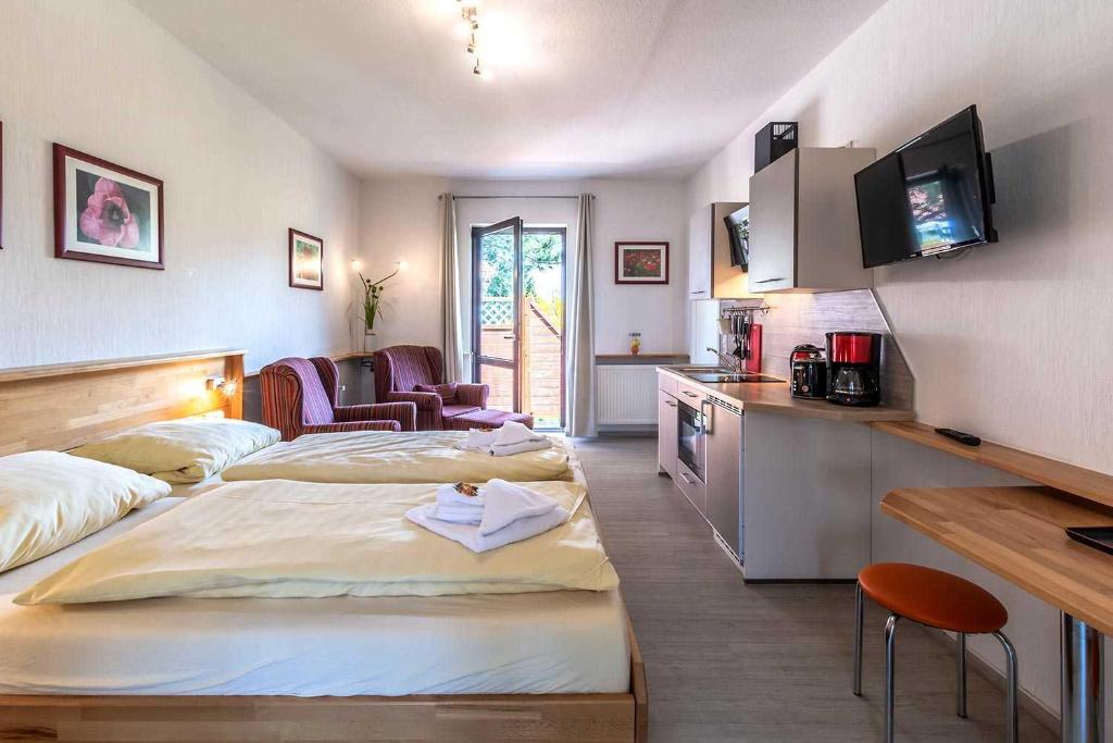 een hotelkamer met 2 bedden en een keuken bij schöne Ferienwohnungen am Lobber Deich in Lobbe