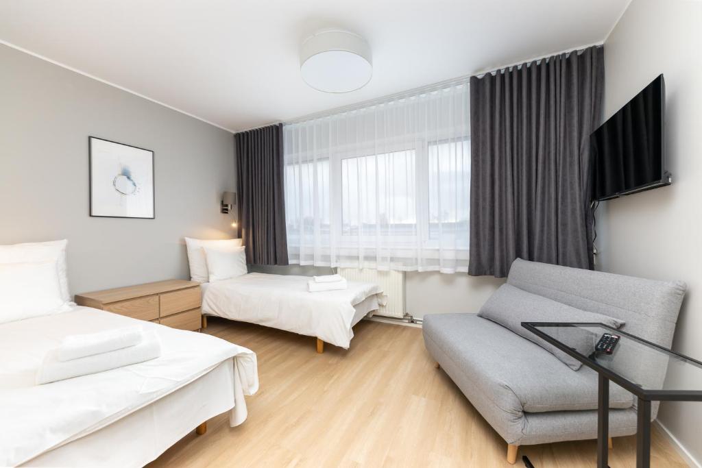 Habitación de hotel con 2 camas y sofá en Reldor Motell en Pärnu