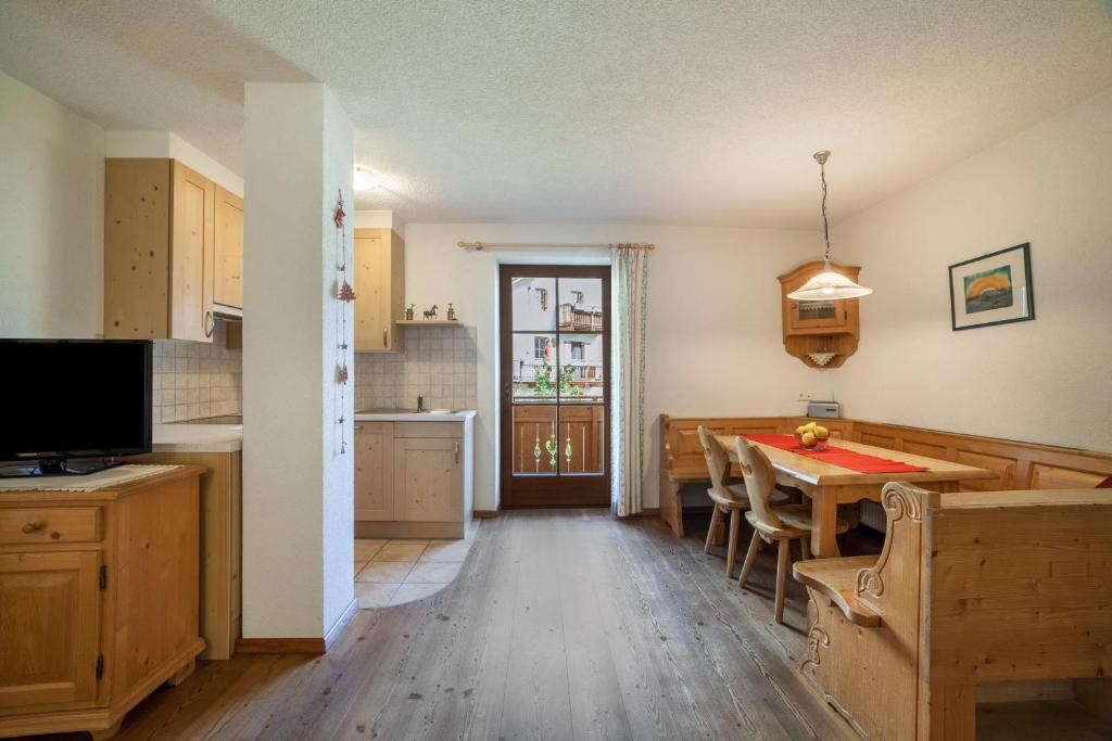 a kitchen with a table and a dining room at Hof am Schloss Apartment Edelweiss in Montechiaro