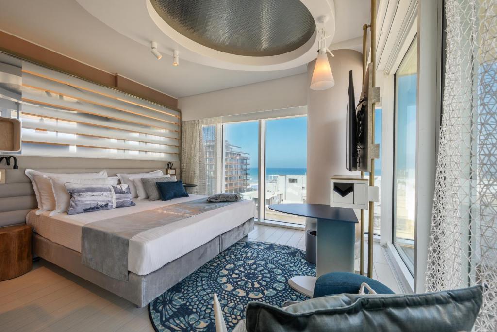 a bedroom with a large bed and a large window at Port Tower by Isrotel Design in Tel Aviv