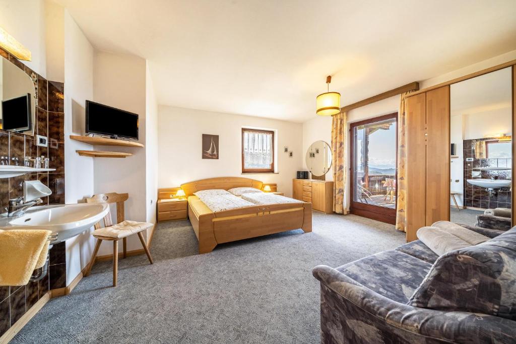 een hotelkamer met een bed, een wastafel en een bank bij Rotsteinhof Apartement Sonnenschein in Verano