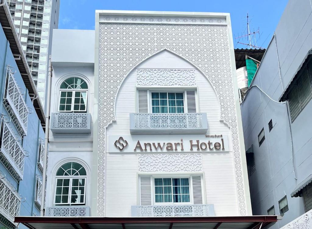 um edifício branco com uma seta de hotel em Anwari Hotel em Banguecoque