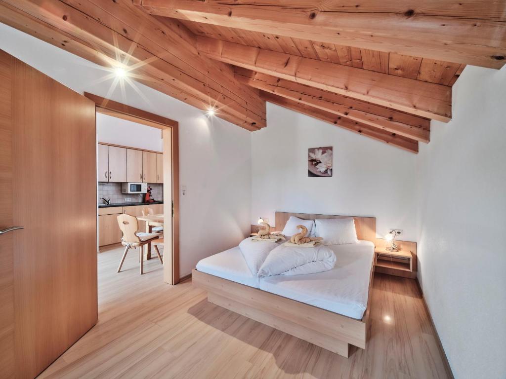 シェッファウ・アム・ヴィルデン・カイザーにあるBerggasthof Bärnstattの木製の天井のベッドルーム1室(ベッド1台付)