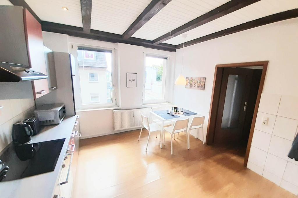Una cocina con una mesa y sillas en una habitación. en CosyHomes24 - Workers apartment with parking space - VE01, en Velbert