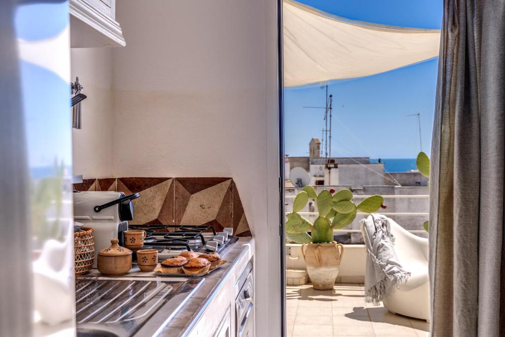 una cucina con fornelli e vista sull'oceano di Il Nido - Le Case di Valentina a Gallipoli