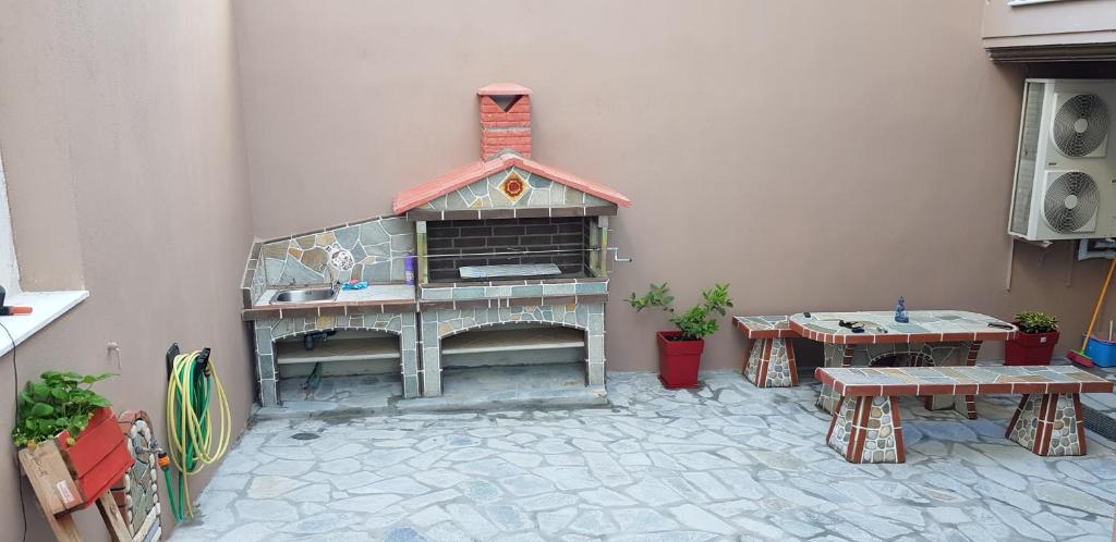 a patio with a fireplace and two tables at ATHINAS APARTMENT in Limenas
