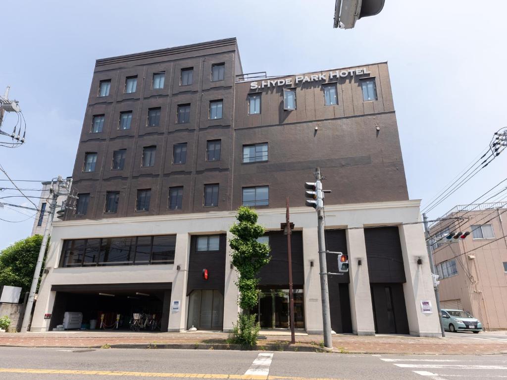 古河市にあるTabist エスハイドパーク 古河駅前の信号のある通り角の茶色い大きな建物