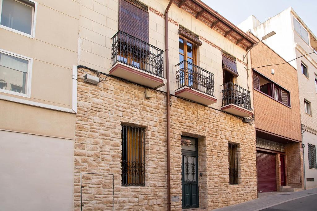 - un bâtiment en briques avec balcon dans une rue dans l'établissement LA CASA MORISCA, à Alicante