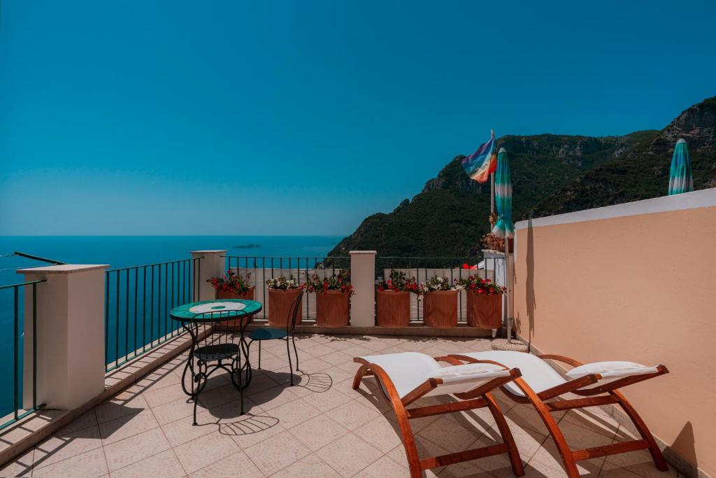 a balcony with a table and chairs and the ocean at Maison Ciccio - il Monticello con Sauna Privata in Positano