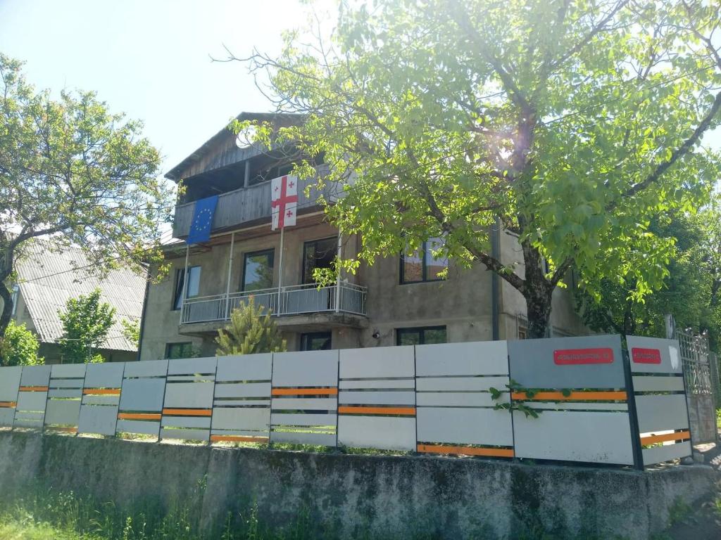 a building behind a concrete wall in front of a building at Villa PorTina in Ambrolauri