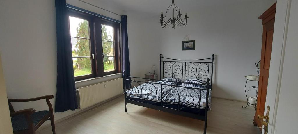 a bedroom with a bed and a window and a chandelier at Zum Alten Pfarrhaus in Damscheid