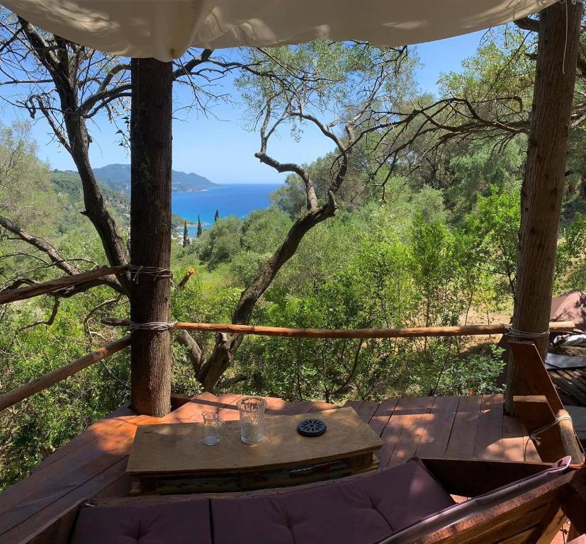een tafel op een terras met uitzicht op de oceaan bij Pelekas Olive Grove Oasis Room No4 in Pelekas