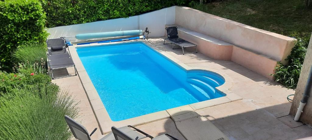 uma vista sobre uma piscina com cadeiras e uma banheira em MAISON PROVENCE AVEC PISCINE PRIVATIVE em Nyons