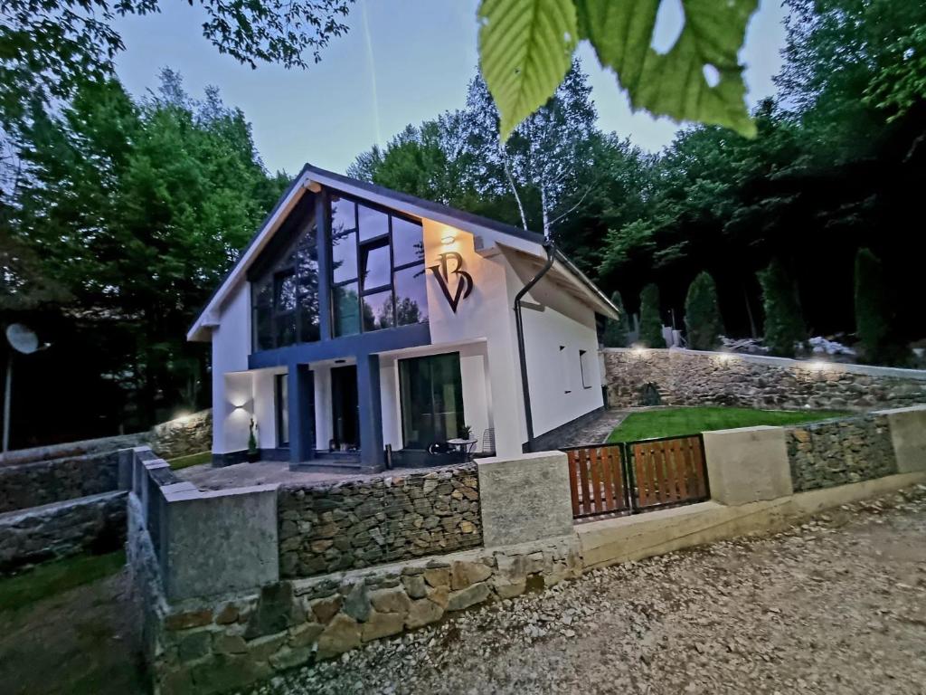 a small house on a stone wall at Vila Blanc Valiug Crivaia in Văliug
