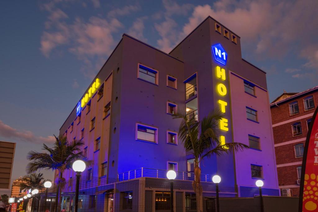 a building with a neon sign on the side of it at N1 Hotel Rotten Row Harare in Harare