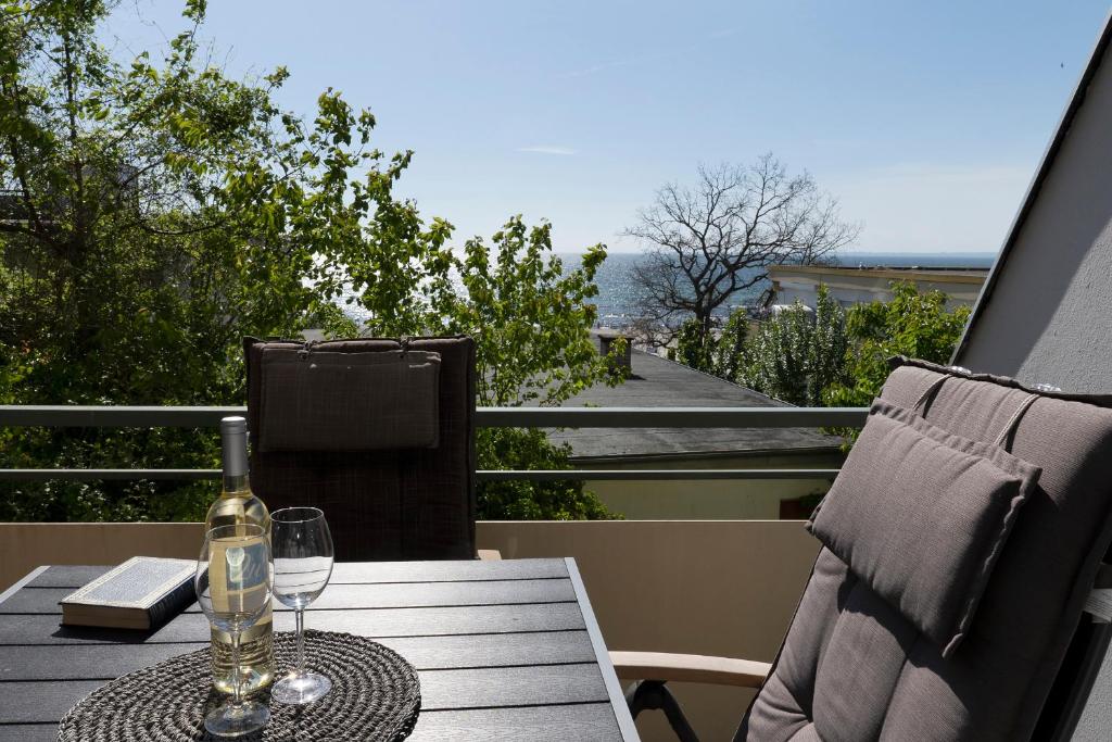 einen Tisch mit einem Glas Wein auf dem Balkon in der Unterkunft Miramar Wohnung 312 in Grömitz