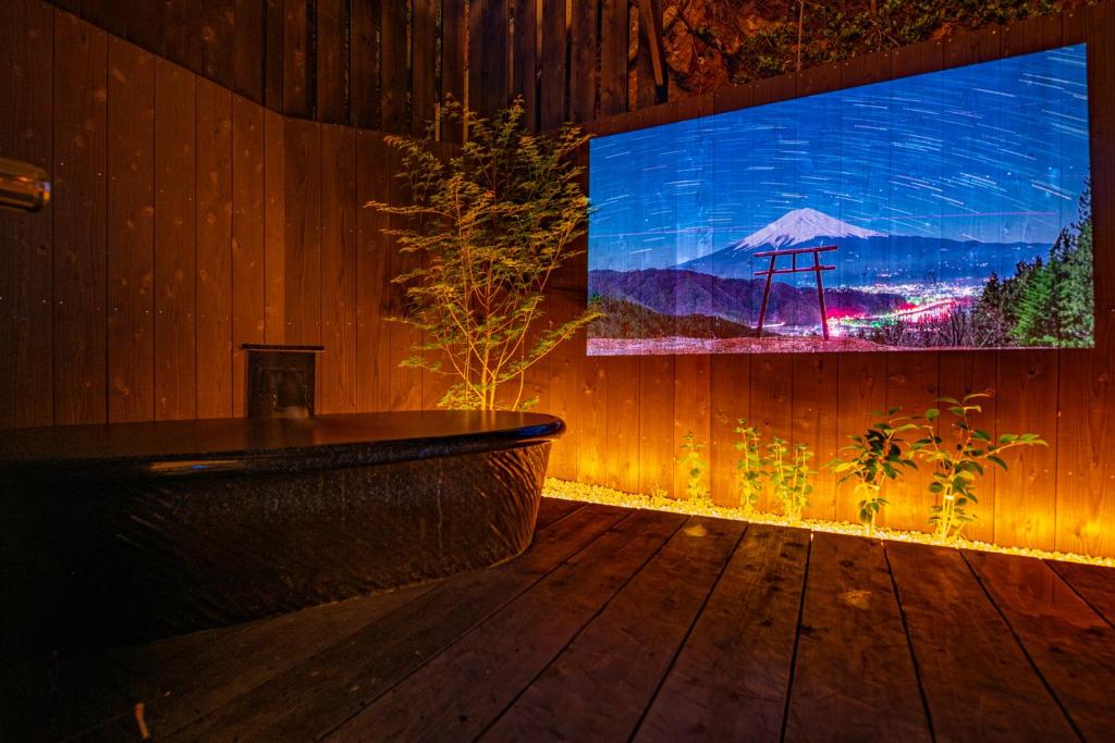 白浜町にある時空間 泉 【白浜最高源泉 甘露の湯】の木製の壁の客室内の大型テレビ付