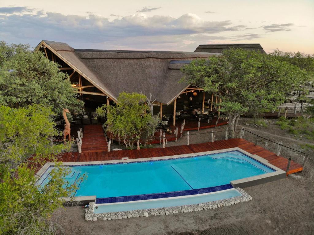 uma imagem de uma casa com piscina em Etosha Oberland Lodge em Okaukuejo