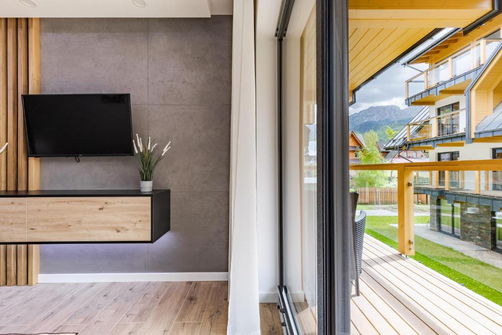 Televízia a/alebo spoločenská miestnosť v ubytovaní Apartamenty Modrzejewskiej Zakopane