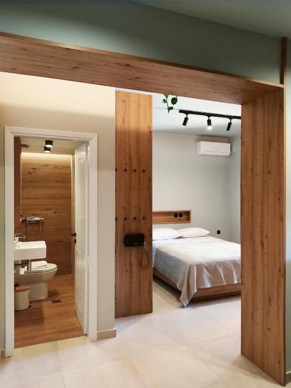 a bedroom with a bed and a bathroom with a sink at Lydia's Rainbow in Preveza