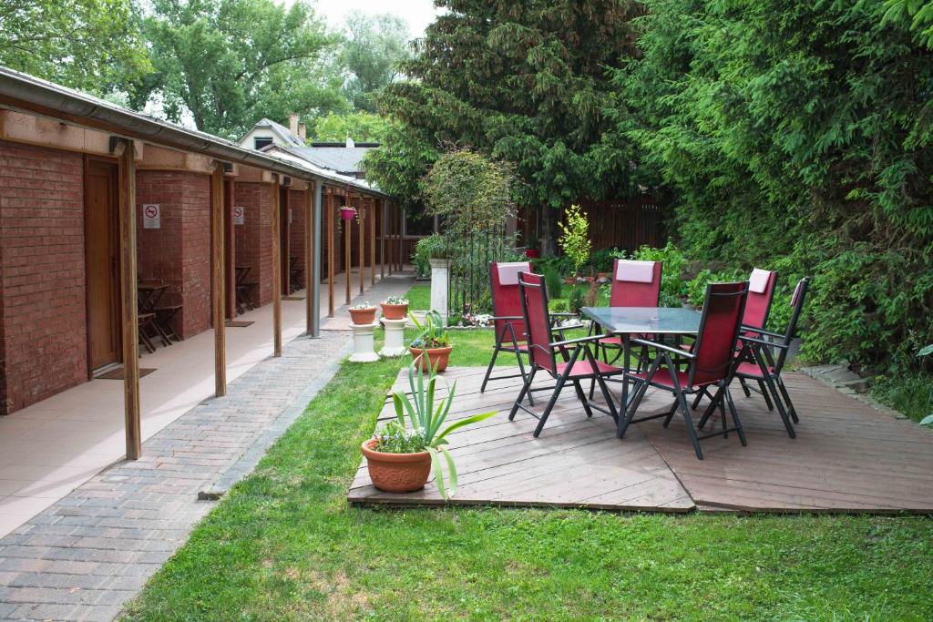 eine Terrasse mit einem Tisch und Stühlen auf dem Rasen in der Unterkunft Duna-Party Pansion in Budapest