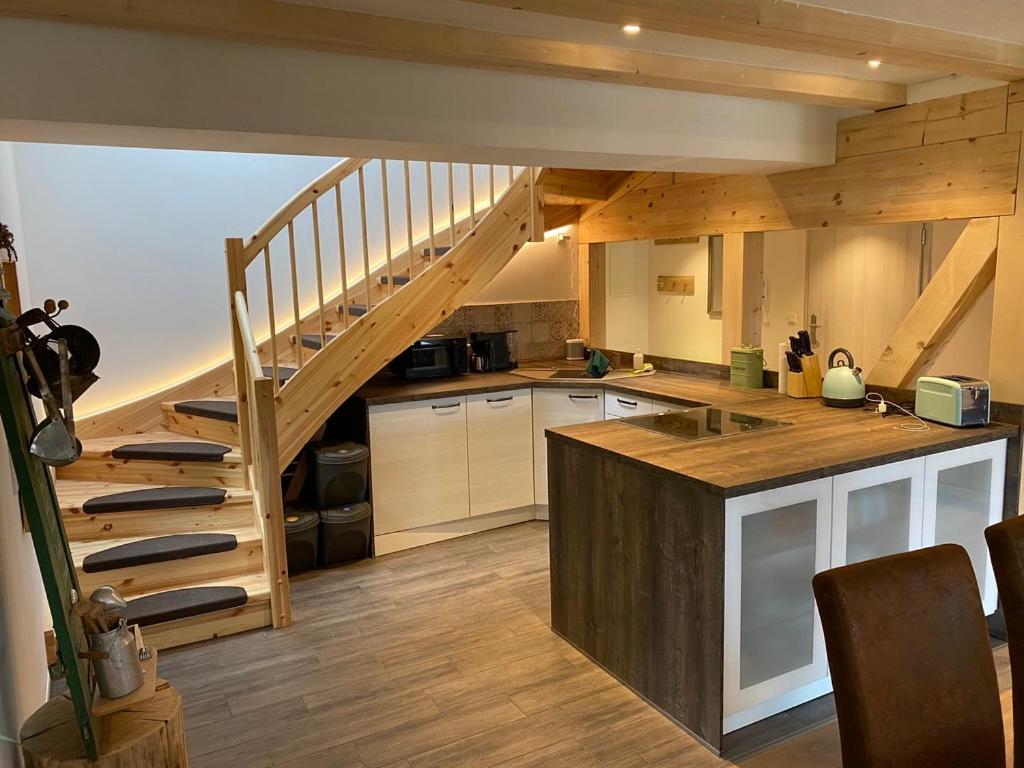 a kitchen with a wooden staircase in a house at Ferienwohnung Lichterhof in Sebnitz