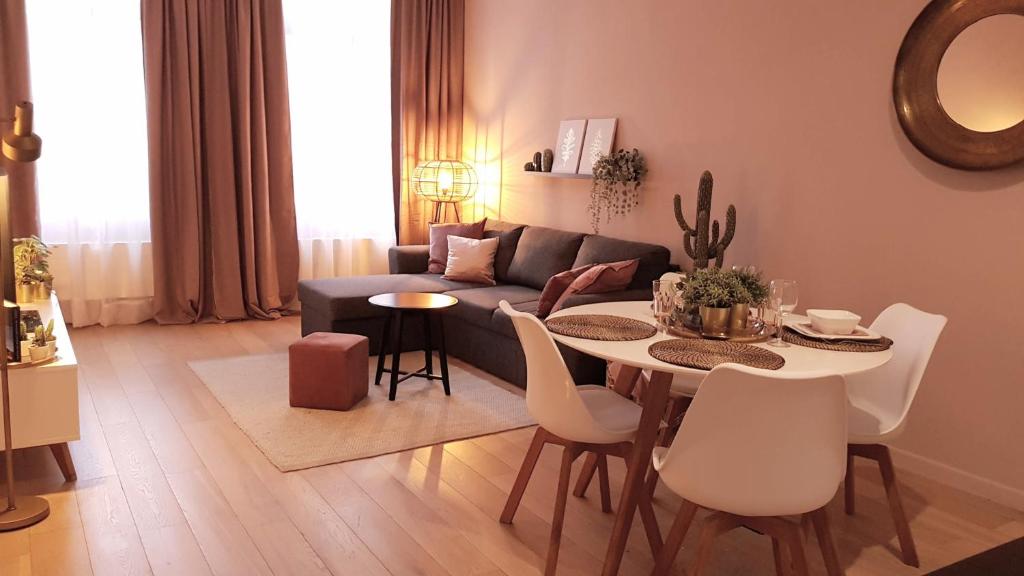 uma sala de estar com um sofá, uma mesa e cadeiras em BnB Antwerpen - CHARMANT em Antuérpia