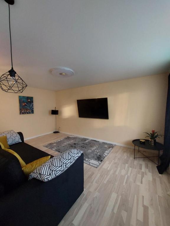 a living room with a couch and a flat screen tv at Narva mnt 23``` in Jõhvi