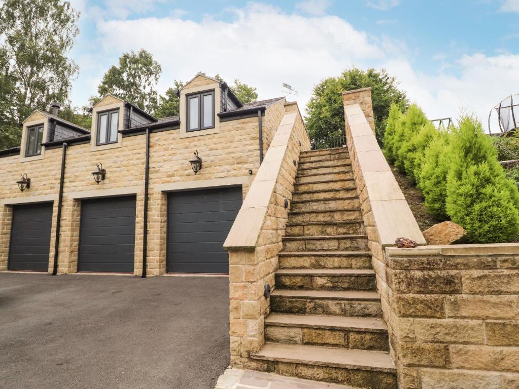 a house with two garage doors and stairs at Woodlands in Keighley