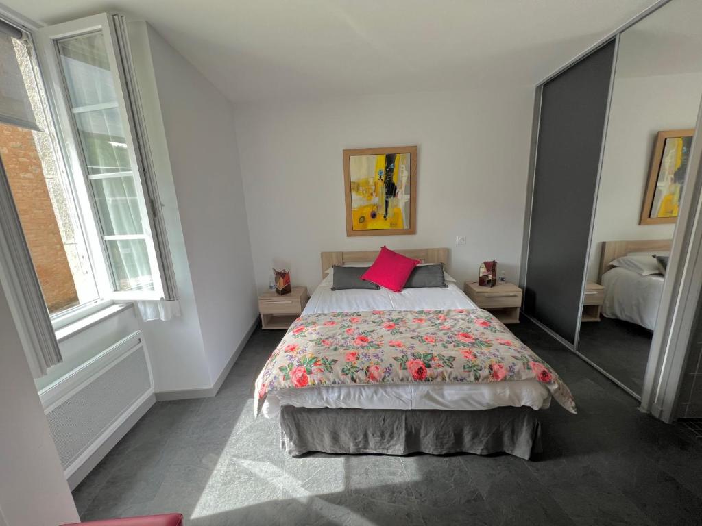 Schlafzimmer mit einem großen Bett und einem roten Kissen in der Unterkunft Les pirondeaux in Rocamadour