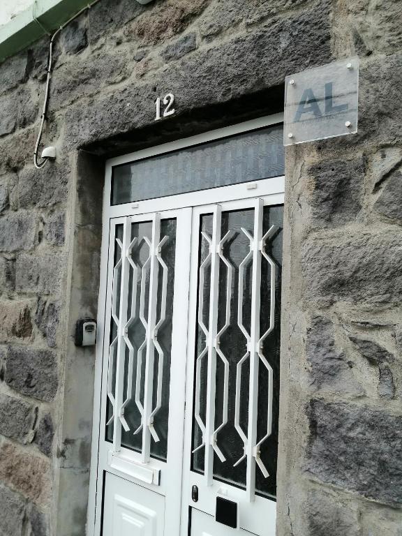 a white door with a sign on a stone building at Casa Dos Mosteiros in Mosteiros