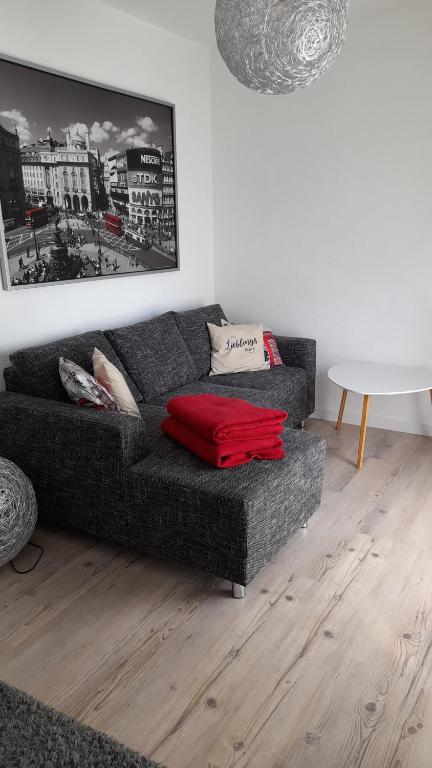 una sala de estar con un sofá con una bolsa roja. en schöne Ferienwohnung am Rande der Altstadt en Lutherstadt Wittenberg