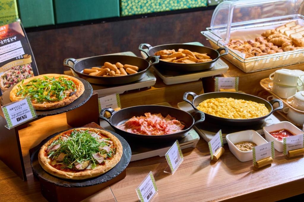 a buffet with pizzas and other food on a table at Kyoto Tower Hotel in Kyoto