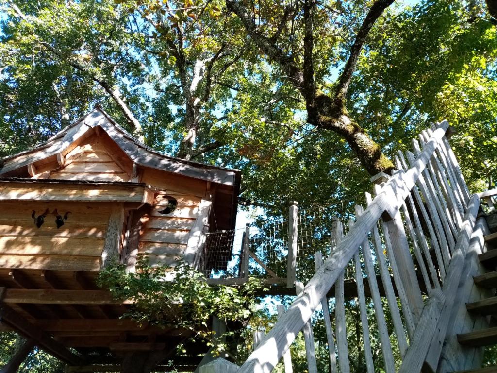 a wooden bird house next to a white fence at Colline de Boutiès in La Barthe