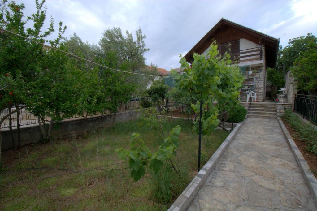 a yard of a house with a fence and trees at kuća za odmor Anić in Pirovac