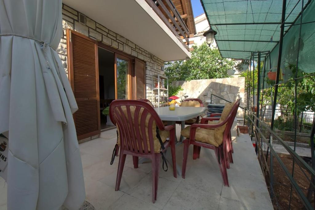 a patio with a table and chairs on a balcony at kuća za odmor Anić in Pirovac