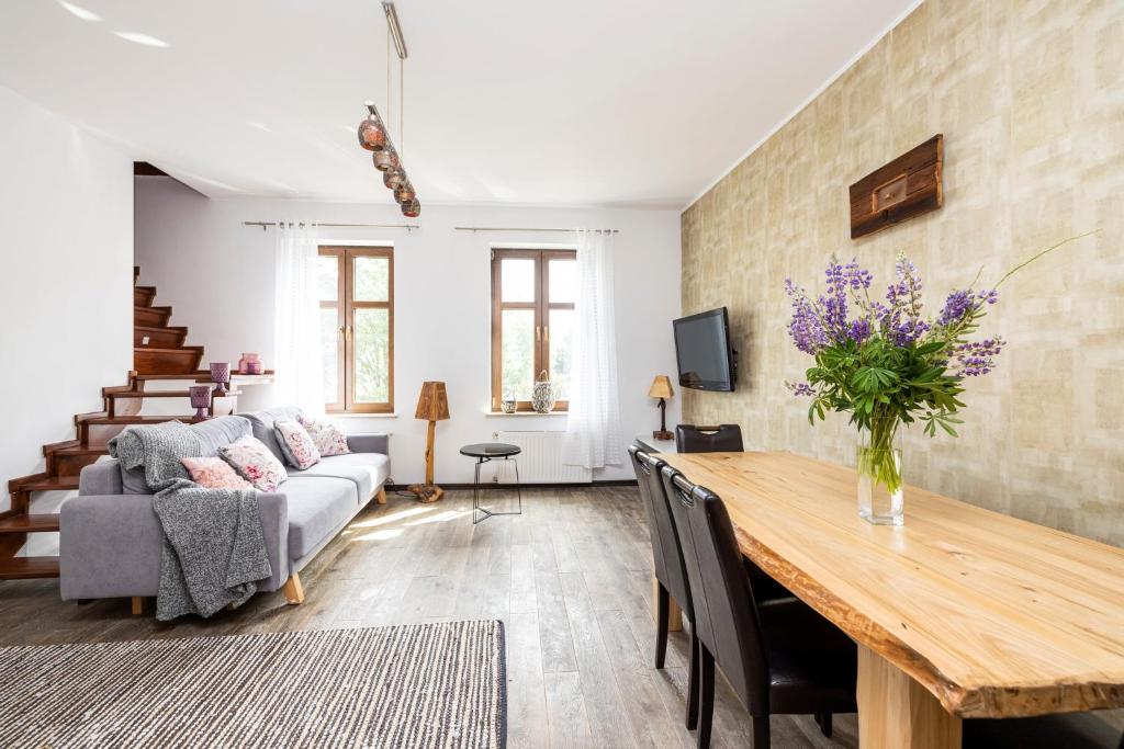 a living room with a table and a couch at Odzieżowa Apartment in Elblag