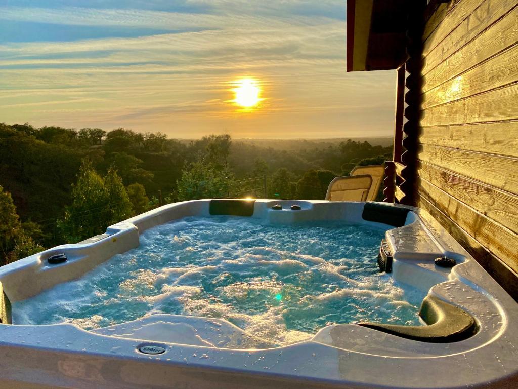 eine Whirlpool-Badewanne mit Sonnenuntergang im Hintergrund in der Unterkunft Montum Farm Living in Melides