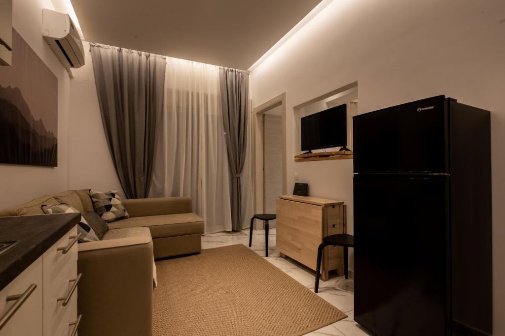 - un salon avec un canapé et un réfrigérateur noir dans l'établissement Luxury apartment in the center of Ioannina city, à Ioannina