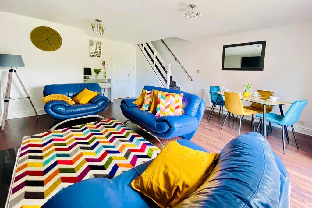 a living room with blue couches and a table at Mayfair Place - Cosy 3 Bedroom House with Free Parking in Birmingham