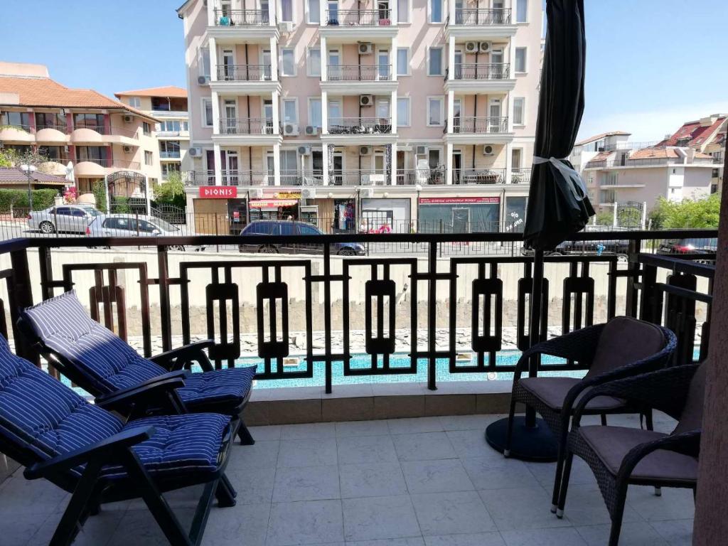 スヴェティ・ヴラスにあるLovely Studio in a Complex with a Pool by Flat Mаnаgerのバルコニー(椅子、パラソル付)